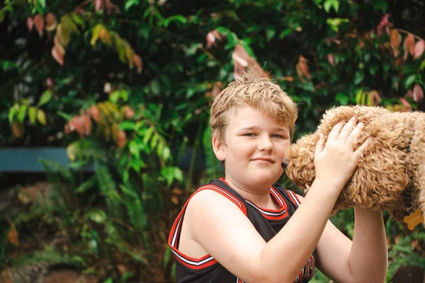 Мальчик Подросток Сидящий Траве Играющий Большой Счастливой Золотой Собакой — стоковое фото