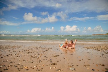Çocuklar Coffs Harbour, NSW Avustralya plajında oynuyorlar.