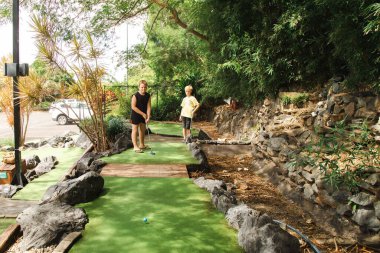 Çocuklar büyük muz eğlence parkında mini golf oynuyorlar, Coffs Harbour NSW Avustralya