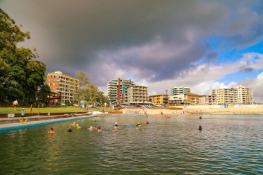 Forster NSW Avustralya - 13 Nisan 2022: Okyanus hamamında sabahın erken saatlerinde arka planda şehir sokak manzarası