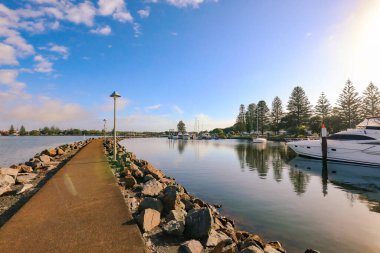 Forster NSW Avustralya - 13 Nisan 2022: Wallis, NSW Avustralya 'daki Forster Marina' da sabah yürüyüşünün tadını çıkaran yaşlı çift