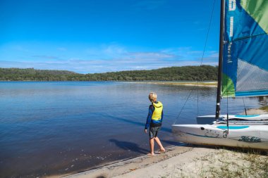 Smith Gölü, NSW Avustralya - 29 Nisan 2022: Çocuklar güneşli bir günde köpüklü kahve kayıkhanesinde yelkencilik dersine katılıyor