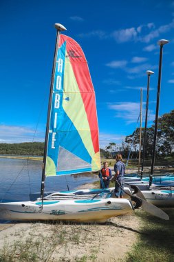 Smith Gölü, NSW Avustralya - 29 Nisan 2022: Çocuklar güneşli bir günde köpüklü kahve kayıkhanesinde yelkencilik dersine katılıyor