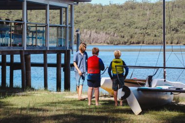 Smith Gölü, NSW Avustralya - 29 Nisan 2022: Çocuklar güneşli bir günde köpüklü kahve kayıkhanesinde yelkencilik dersine katılıyor