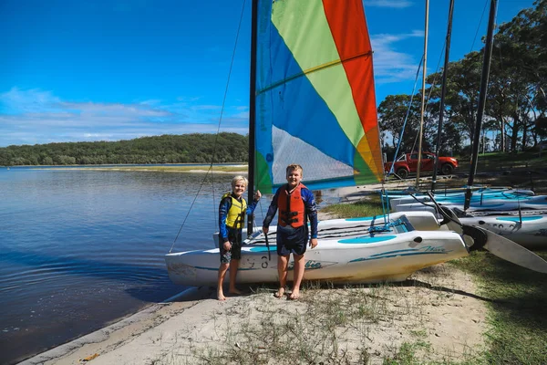 Smith Gölü, NSW Avustralya - 29 Nisan 2022: Çocuklar güneşli bir günde köpüklü kahve kayıkhanesinde yelkencilik dersine katılıyor