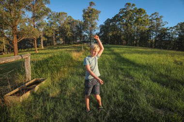 Çiftlikteki çocuk taze yumurtayı havada tutuyor.