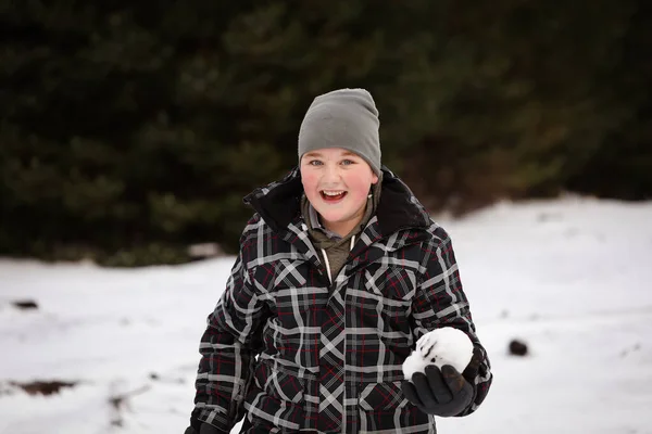 Boy in the snow with snow ball having snowball fight