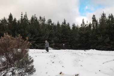 Karlı kış harikalar diyarında oynayan çocuğun manzara görüntüsü