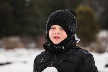 Karlı kış harikalar diyarında oynayan mutlu çocuk