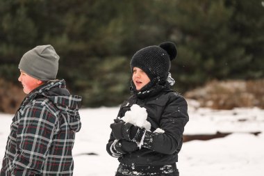 Karlı kış harikalar diyarında oynayan mutlu çocuklar