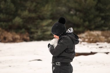 Karlı kış harikalar diyarında oynayan genç çocuk