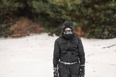 Karlı kış harikalar diyarında kar elbisesi içinde oynayan genç bir çocuk