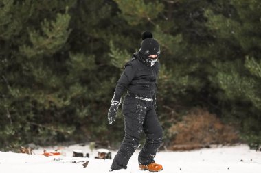 Karlı kış harikalar diyarında kar elbisesi içinde oynayan genç bir çocuk