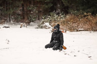 Karlı kış harikalar diyarında kar elbisesi giyen genç bir çocuk