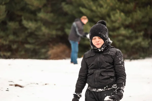 Счастливый Мальчик Играет Снегу Отцом Делает Снеговика Заднем Плане — стоковое фото