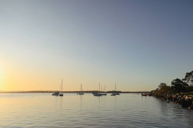 Günbatımında Clarence Nehri 'ne demirlemiş yatlar. Iluka NSW Avustralya