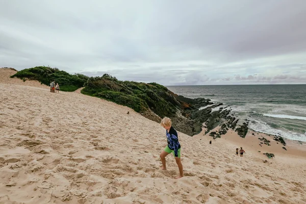 ニューサウスウェールズ州のForsterのビーチ近くで大きな砂の砂丘を登る子供たちオーストラリア — ストック写真