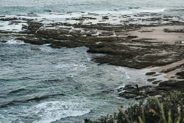 Gentle Waves Breaking Rocks Beach Man Fishing Distance — kuvapankkivalokuva