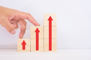 Kariyer merdiveni iş büyümesi başarı süreci konsepti için. Tahta bloklarda, yukarı doğru ok ile basamaklı merdiven şeklinde elle basamaklar.