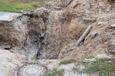 İnşaat alanında yeraltı fırtına kanalizasyon boruları döşemek. Arka plandaki vinçlere ve mavi gökyüzüne su borusu ve hijyenik kanalizasyon kurulumu. Yeraltı suyu drenaj sistemi boruları