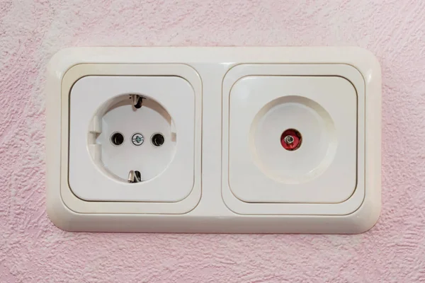 two different sockets in the wall, close-up. Socket for electricity and for the Internet.