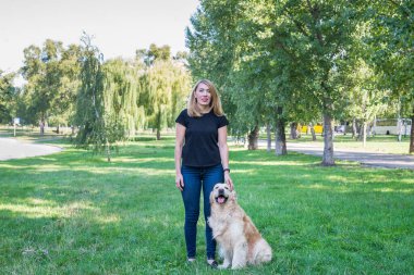 Parkta av köpeği olan genç bir kadın..