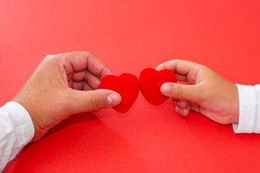 Yetişkinler ve çocuklar ellerinde kırmızı kalp, sağlık, bağış ve aile sigortası konsepti, dünya kalp günü, dünya sağlık günü, CSR konsepti, koruyucu aile evlat edinmesi