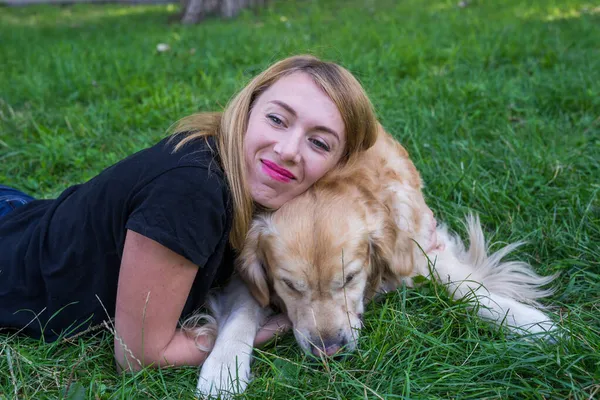 Молодая Женщина Обнимает Свою Собаку Ретривер Лежа Траве — стоковое фото