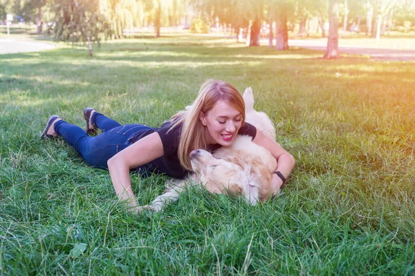 Mujer Joven Abraza Perro Recuperador Mientras Está Acostado Hierba — Foto de Stock