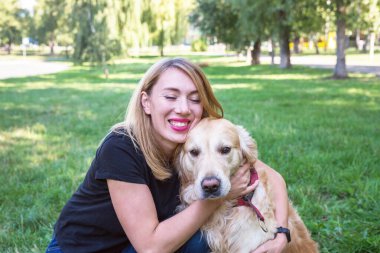 Mutlu genç kadın av köpeğini dışarıda kucaklıyor..
