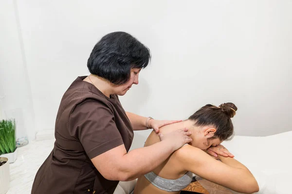 Masażystka Masuje Kark Lub Plecy Młodej Klientce Salonie Masażu — Zdjęcie stockowe