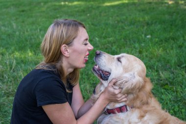 Kadın parkta av köpeğiyle eğleniyor, yüzünü buruşturuyor..
