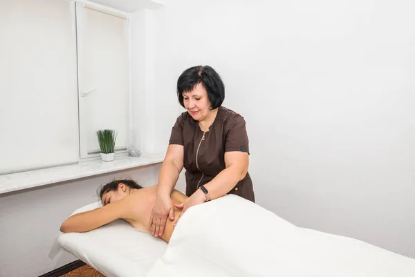 Una Massaggiatrice Donna Massaggio Alla Schiena Una Giovane Ragazza Salone — Foto Stock