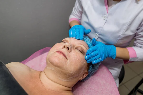 Esteticista Massageia Rosto Cabeça Uma Mulher Adulta Deitada Uma Mesa — Fotografia de Stock