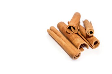 Tarçın çubukları beyaz arkaplanda izole edilmiş ve sol tarafta kopyalama alanı var.