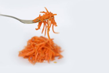 Beyaz üzerinde Kore havuçları olan çatal..