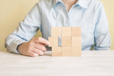 İş kadınının eli bir gruptan tahta bir blok seçti.