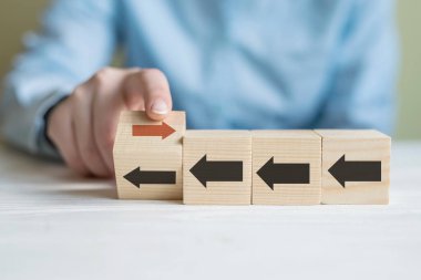 Elinle tahta bloğu çevir. Kırmızı ok ters yöne baksın. Siyah oklar, Eşsiz, farklı düşün, bireysel ve kalabalığın konseptinden uzak dur.