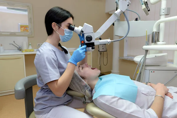 Dentystka Bada Młodą Piękną Kobietę Patrzy Zęby Profesjonalnym Mikroskopem Gabinecie — Zdjęcie stockowe