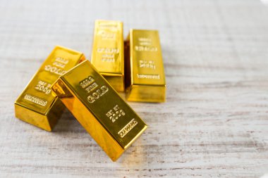 Tahta bir masanın üzerinde bir yığın altın ve kopya alanı var.