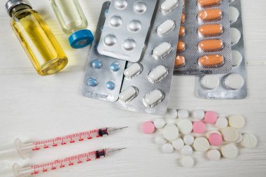 Çeşitli ilaçlar var. Şırıngalar, haplar, aşılar, beyaz kavanozlar. Tıbbi konsept.