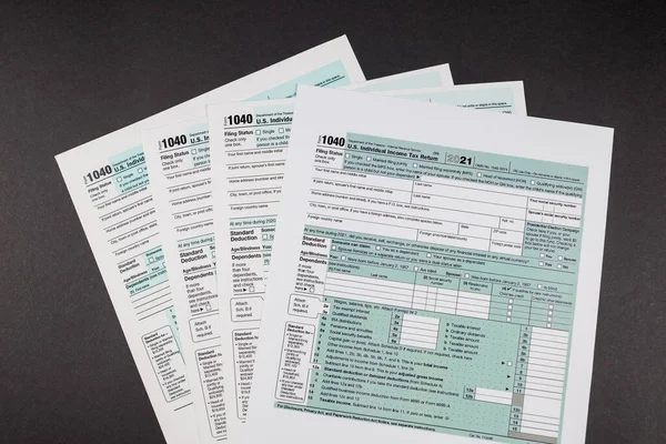 Tax forms 1040 on a black background. Filling out a tax return.