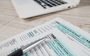 1040 numaralı vergi formunda klavye ve arka planda bir kalem var. Yakın plan..