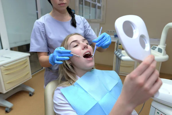 Pacjent Otwartymi Ustami Patrzy Lustro Siedząc Fotelu Dentysty — Zdjęcie stockowe