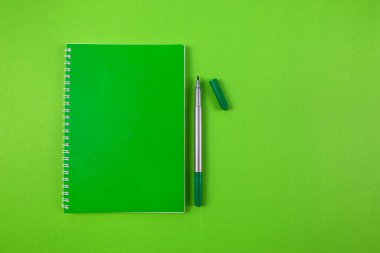Yeşil keçeli yeşil kalemli yeşil not defterinin üst görüntüsü. Boşluğu sağda kopyala.