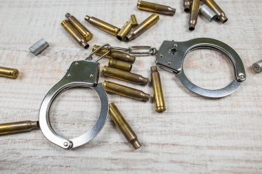 Kelepçeler ve boş mermiler masada.