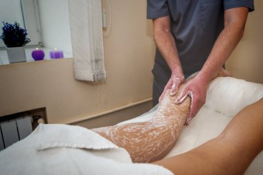 Spa salonundaki ayak fırçası. Erkek masör, profesyonel vücut fırçasıyla ayak masajı yapıyor..