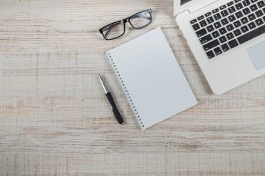 Not defteri ve kalemle beyaz dizüstü bilgisayarın en üst görüntüsü. Boşluğu kopyala.