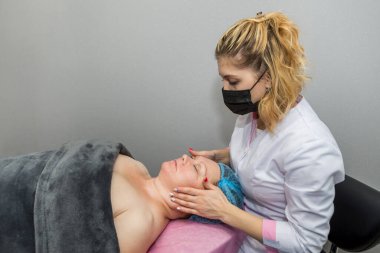 Profesyonel bir güzellik uzmanı bir kadına elle masaj yapar..