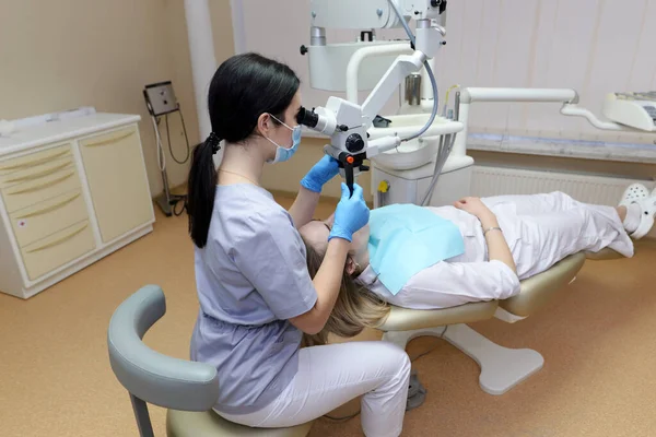 Женщина Дантист Осматривает Молодую Женщину Смотрящую Зубы Профессиональным Микроскопом Хирургическом — стоковое фото